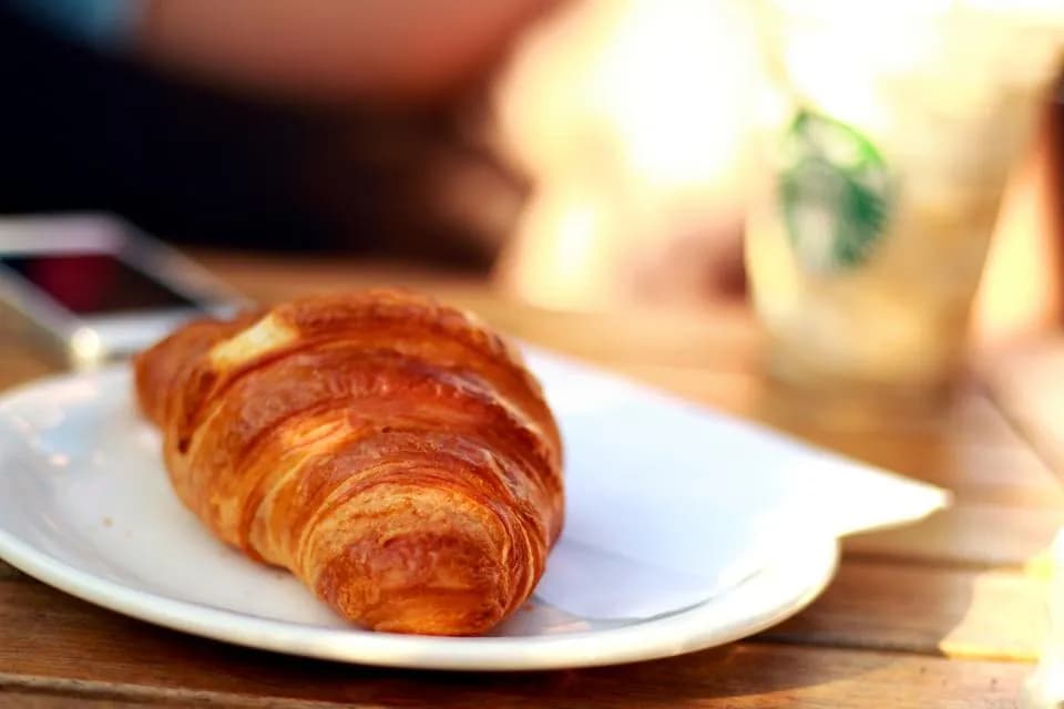 Croissant de mantequilla: Hojaldre de mantequilla, crocante y dorado, con capas que se deshacen en la boca