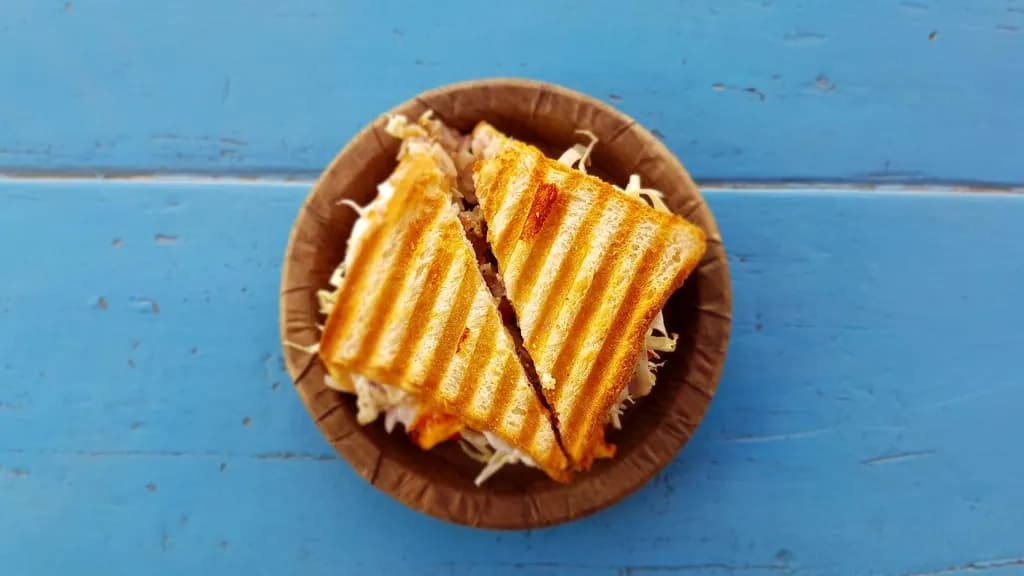 Sándwich de jamón y queso: Pan tajado tostado a la plancha con jamón y queso derretido. Crocante por fuera,